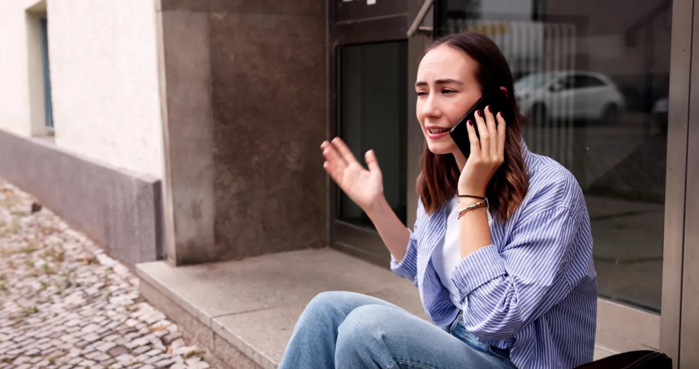 Woman calling a locksmith because she;'s locked out of her house
