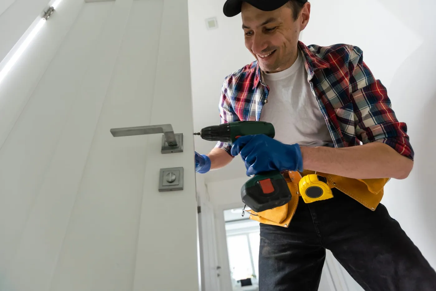 Locksmith fixng the front door latch on a house