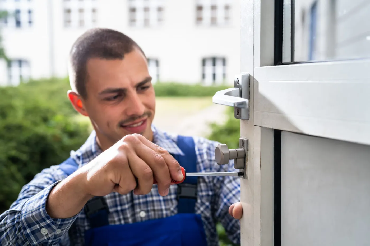 Locksmith using a scewdriver to remove a deadbolt on a door